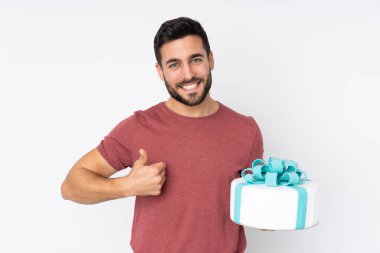 Büyük pastalı pasta şefi beyaz arka planda izole edilmiş, başparmakları havada, çünkü iyi bir şey oldu.