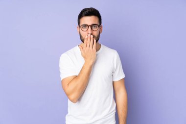 Kafkas yakışıklı adam izole edilmiş arka planda ağzını eliyle kapatıyor.