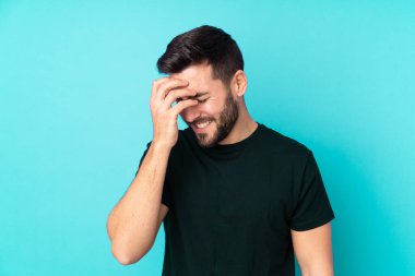 Beyaz tenli yakışıklı adam mavi arka planda izole edilmiş gülüyor.