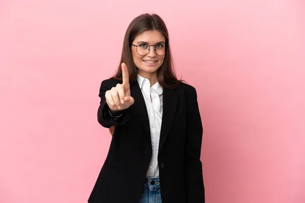 年轻的商界白种人女子 因粉红的背景而被隔离 露出并举起一只手指头 — 图库照片