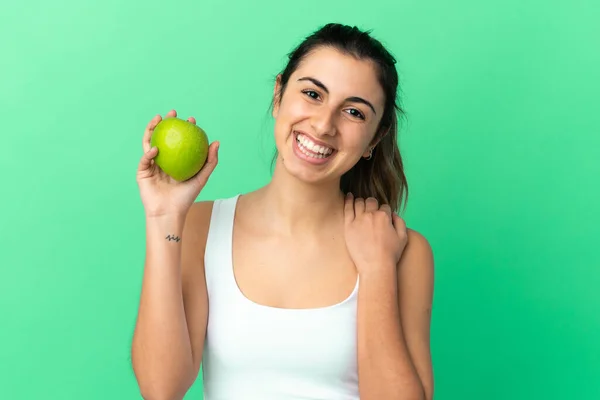 Junge Kaukasische Frau Isoliert Auf Grünem Hintergrund Mit Einem Apfel — Stockfoto