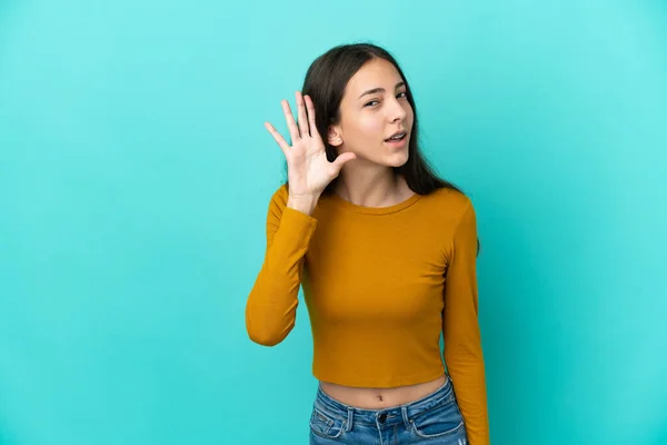 Joven Francesa Aislada Sobre Fondo Azul Escuchando Algo Poniendo Mano —  Fotos de Stock