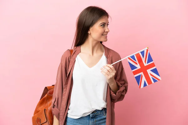 年轻的高加索女人 手持一面英国国旗 呈粉红色背景 侧面相望 — 图库照片