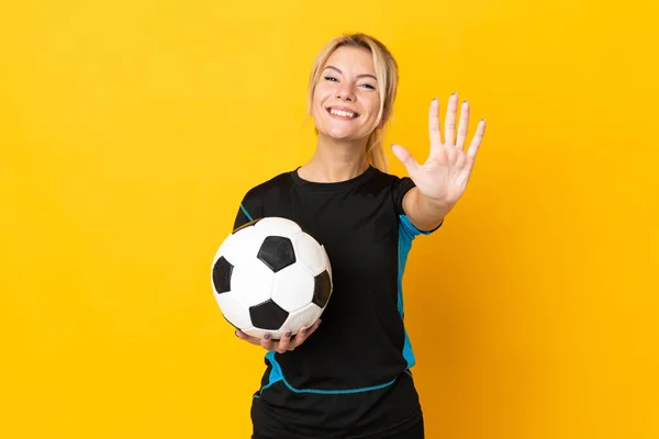 Young Russian football player woman isolated on yellow background counting five with fingers