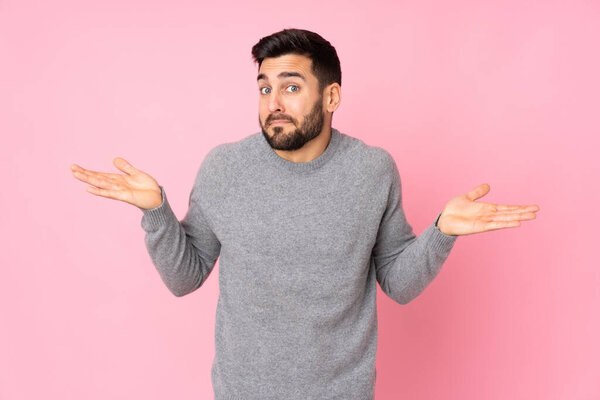 Caucasian handsome man over isolated background making doubts gesture