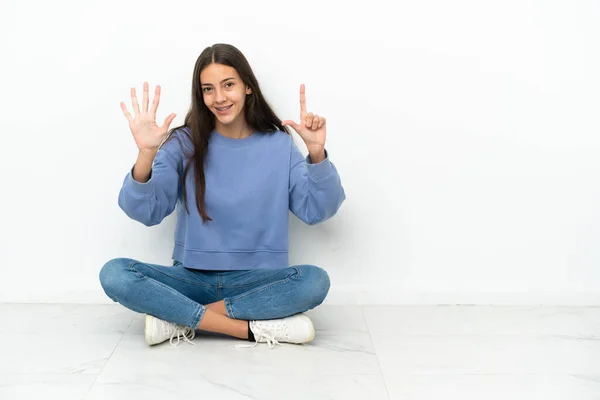 一个年轻的法国姑娘坐在地板上 用手指数着七 — 图库照片