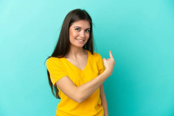 stock image Young caucasian woman isolated on blue background pointing back