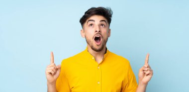 Münzevi geçmişi olan yakışıklı Arap bir adam şaşırmış ve yukarı bakıyor.