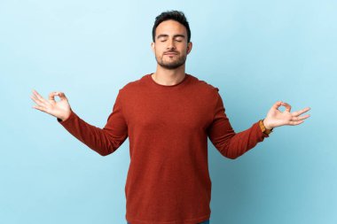 Zen pozisyonunda izole edilmiş genç yakışıklı bir adam.