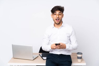 Beyaz arka planda izole edilmiş bir bürodaki Arap adam şaşırdı ve bir mesaj gönderiyor.