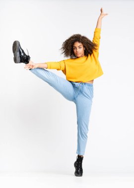 Genç Afrikalı Amerikalı kadın izole beyaz arka planda dans ediyor.