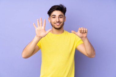 İzole edilmiş geçmişi olan yakışıklı Arap bir adam parmaklarıyla altı kişi sayıyor.