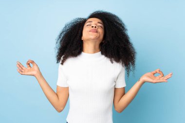 Genç Afro-Amerikalı kadın Zen pozuyla izole edilmiş.