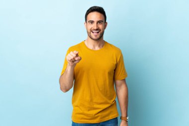 Tecrit edilmiş genç yakışıklı adam şaşırmış ve ön tarafı işaret ediyor.