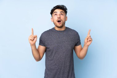 Münzevi geçmişi olan yakışıklı Arap bir adam şaşırmış ve yukarı bakıyor.