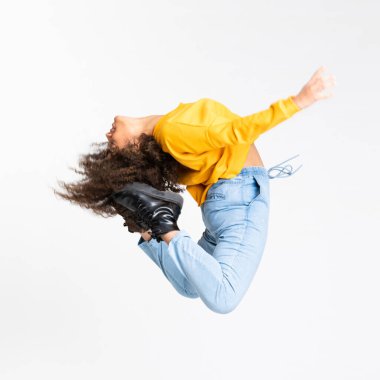 Genç Afrikalı Amerikalı kadın izole beyaz arka planda dans ediyor.