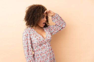 Genç Afro-Amerikalı kadın bej arka planda izole edildi.