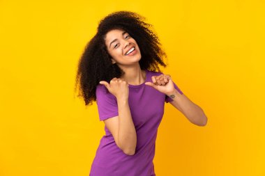 Tecrit edilmiş bir geçmişi olan genç Afrikalı Amerikalı kadın bir ürünü sunmak için kenarı işaret ediyor.