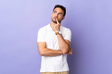 Mor arka planda izole edilmiş genç ve yakışıklı bir adam.