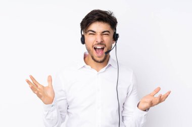 Tele pazarlamacı Arap bir adam beyaz arka planda izole edilmiş bir kulaklıkla çalışıyor mutsuz ve hayal kırıklığına uğramış bir şekilde.