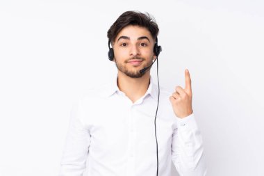Beyaz arka planda izole edilmiş kulaklıkla çalışan pazarlamacı Arap adam işaret parmağıyla işaret etmek harika bir fikir.