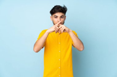 Münzevi geçmişi olan yakışıklı Arap bir adam sessizlik işareti gösteriyor.