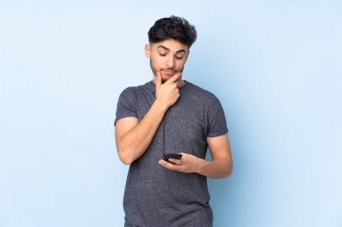 Arap yakışıklı bir adam soyutlanmış arka planda düşünüyor ve mesaj gönderiyor.