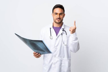 Beyaz arka planda izole edilmiş bir radyografi tutan genç doktor işaret parmağıyla işaret etmek harika bir fikir.