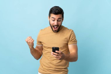 Sakallı, sakallı, genç ve yakışıklı bir adam şaşırmış ve bir mesaj gönderiyor.
