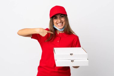 Pizza teslimatçısı kadın elinde pizza tutuyordu. Koronavirüsten koruyordu. Yüzünde sürpriz bir ifade olan beyaz bir maskeyle.