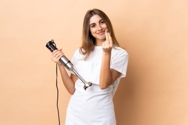 İzole arka planda el blenderi kullanan kadın para hareketi yapıyor