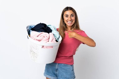 Elinde çamaşır sepeti olan genç bir kadın beyaz arka planda izole edilmiş ve yüzünde sürpriz bir ifade var.