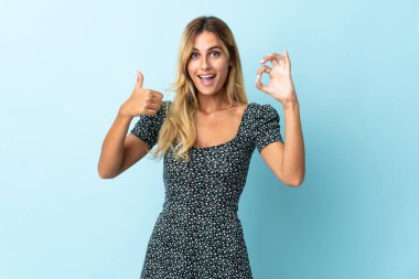 Genç sarışın Uruguaylı, mavi arka planda izole edilmiş.