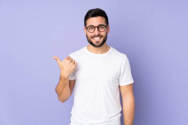 Kafkasyalı yakışıklı, soyutlanmış bir geçmişi olan bir adam bir ürün sunmak için kenarı işaret ediyor.