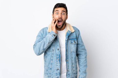 Beyaz arka planda sakallı yakışıklı, şaşırmış ve şok olmuş bir yüz ifadesi olan genç adam.