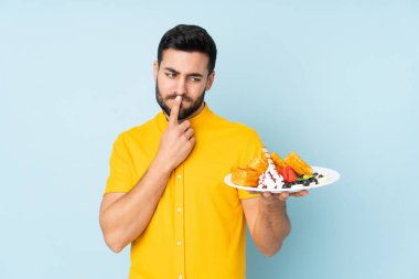 Beyaz adam mavi arka planda gözleme tutuyor.