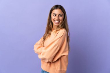 Kolları çapraz ve mutlu bir şekilde izole edilmiş, mor bir geçmişi olan genç İspanyol bir kadın.