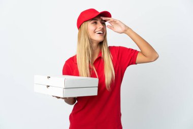 Pizza dağıtan kadın beyaz arka planda izole edilmiş pizza tutuyor. Çok gülümsüyor.