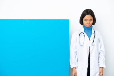 Beyaz arka planda, üzgün bir ifadeyle izole edilmiş, büyük bir afişi olan genç, melez bir doktor kadın.