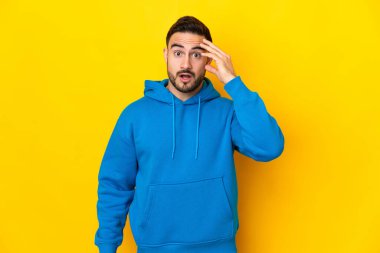 Sarı arka planda izole genç beyaz yakışıklı adam bir şey fark etti ve çözüme niyetlendi.