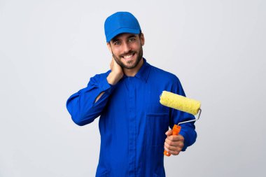 Beyaz arka planda izole edilmiş bir boya silindiri tutan ressam gülüyor.