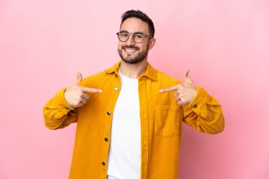 Beyaz tenli yakışıklı adam pembe arka planda soyutlanmış gururlu ve kendini beğenmiş.