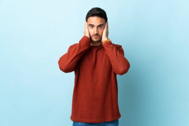 Tecrit edilmiş genç yakışıklı adam hayal kırıklığına uğramış ve kulaklarını kapatmış.