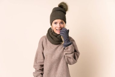 Kış şapkalı genç bir kadın izole bir arka planda gergin ve korkmuş.