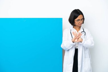 Beyaz arka planda izole edilmiş büyük bir afişi olan genç melez doktor kadın bir hareketi durdurmak için eliyle jest yapıyor.