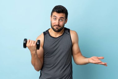 Sakallı genç sporcu ağırlık kaldırırken omuzlarını kaldırırken şüphe yapıyor.