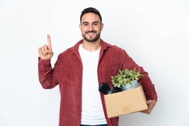 Beyaz arka planda izole edilmiş eşyalarla dolu bir kutuyu kaldırırken beyaz bir adam hamle yapıyor.