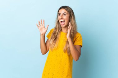 Soyutlanmış mavi bir geçmişi olan genç İspanyol bir kadın. Sürpriz bir yüz ifadesi var.