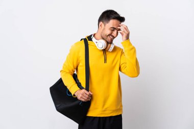 Spor çantalı genç adam beyaz arka planda izole edilmiş gülüyor.