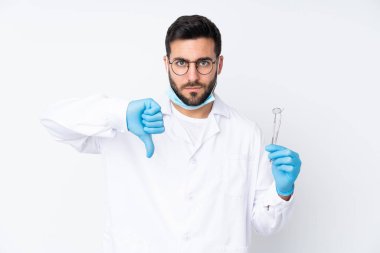 Beyaz arkaplanda parmak izi gösteren araçları tutan dişçi.